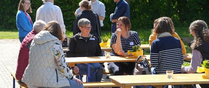 Synodalversammlung_2024 mit Menschen im Gespräch in der Sonne stehend und sitzend