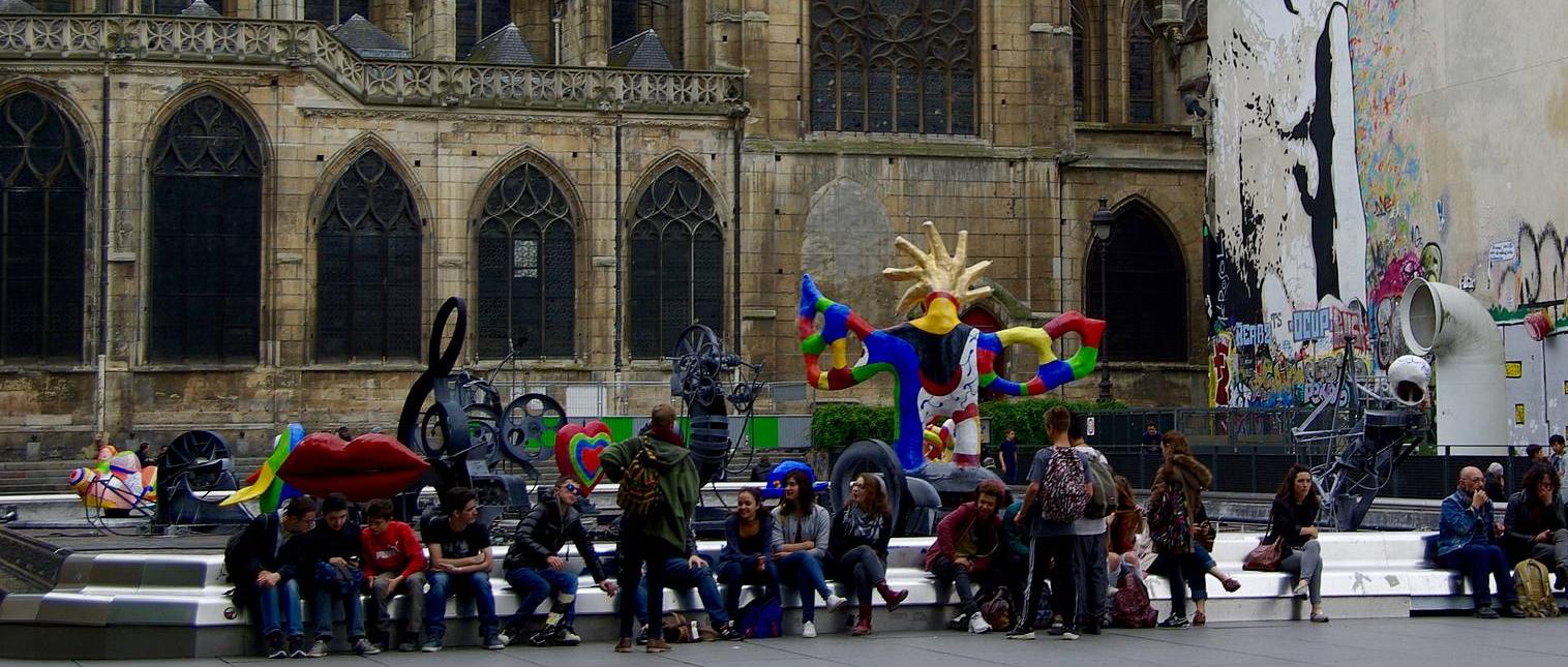 Bildende Kunstwelten - Foto mit Kunstwerken und Menschen vor einer Kirche