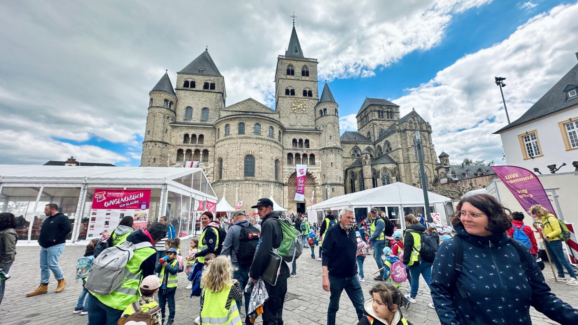 Man sieht den Trierer Dom, Zelte, Pavillions, Fahnen und viele Menschen, die auf dem Domfreihof sind im Rahmen der Heilig-Rock-Tage
